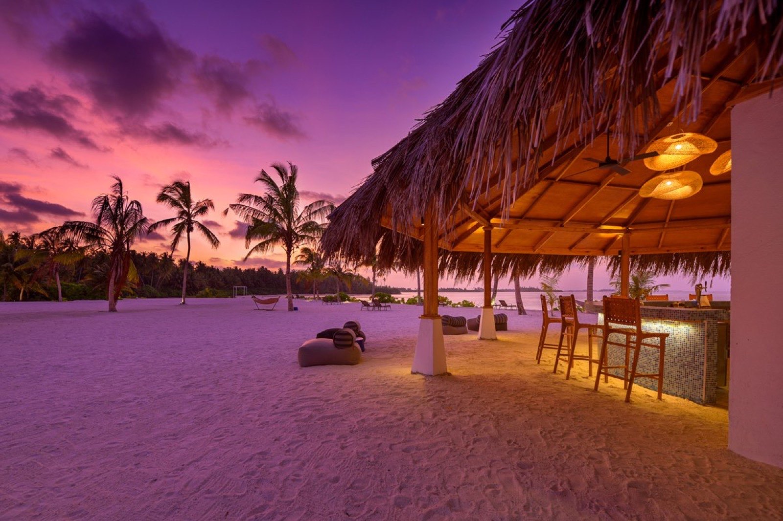 Ko' Bar at sunset, with seating looking out over the water as the sky turns orange.