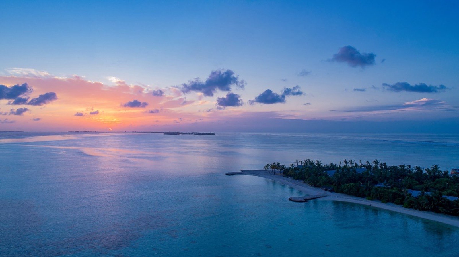 Dawn over the lagoon, the sun low and the water still.